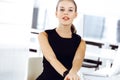 Young blond businesswoman working on computer while sitting at the desk in modern office. Business people concept. Black Royalty Free Stock Photo