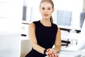 Young blond businesswoman working on computer while sitting at the desk in modern office. Business people concept. Black Royalty Free Stock Photo