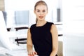 Young blond businesswoman working on computer while sitting at the desk in modern office. Business people concept. Black Royalty Free Stock Photo