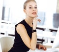 Young blond businesswoman working on computer while sitting at the desk in modern office. Business people concept Royalty Free Stock Photo