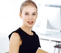Young blond businesswoman working on computer while sitting at the desk in modern office. Business people concept Royalty Free Stock Photo
