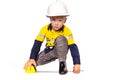 Young blond caucasian boy measuring something role playing as a construction worker in a yellow and blue hi-viz shirt Royalty Free Stock Photo
