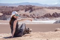 Young blond caucasian girl sitting and admiring outstanding landscape of untouched nature in Atacama desert, Chile Royalty Free Stock Photo