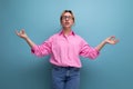 young blond caucasian woman model with ponytail hairstyle in a stylish outfit consisting of a pink blouse and jeans is Royalty Free Stock Photo