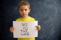 Young blond child, holding sign in support to peace, no war wanted, kid wishing peaceful life