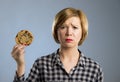 Young blond cute and friendly caucasian woman in casual clothes holding big delicious chocolate cookie Royalty Free Stock Photo