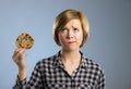 Young blond cute and friendly caucasian woman in casual clothes holding big delicious chocolate cookie Royalty Free Stock Photo