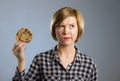 Young blond cute and friendly caucasian woman in casual clothes holding big delicious chocolate cookie Royalty Free Stock Photo