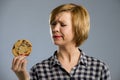 Young blond cute and friendly caucasian woman in casual clothes holding big delicious chocolate cookie Royalty Free Stock Photo