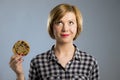 Young blond cute and friendly caucasian woman in casual clothes holding big delicious chocolate cookie Royalty Free Stock Photo