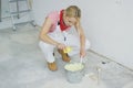 Woman mixing wall paint in bucket