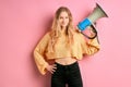 Portrait of young smiling caucasian girl with loud speaker, megaphone