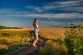 Young blond girl on the background of the rural landscape Royalty Free Stock Photo