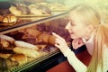 Young blond girl gladly selecting pastry