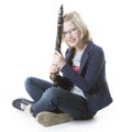 Young blond girl sits and holds clarinet in studio
