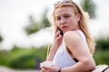 Young blond girl talking on cell phone. Facial expressions Royalty Free Stock Photo