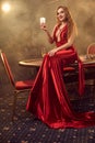 Young beautiful woman is posing against a poker table in luxury casino. Royalty Free Stock Photo