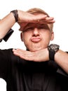 Young blond man in a black shirt, watches and bracelet is making faces, isolated on a white background Royalty Free Stock Photo