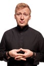 Young blond man in a black shirt, watches and bracelet is making faces, isolated on a white background Royalty Free Stock Photo