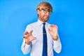 Young blond man wearing business clothes and glasses disgusted expression, displeased and fearful doing disgust face because Royalty Free Stock Photo