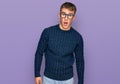 Young blond man wearing casual clothes and glasses afraid and shocked with surprise expression, fear and excited face Royalty Free Stock Photo