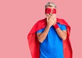 Young blond man wearing super hero custome shocked covering mouth with hands for mistake Royalty Free Stock Photo