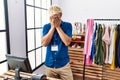 Young blond man working as manager at retail boutique with sad expression covering face with hands while crying Royalty Free Stock Photo