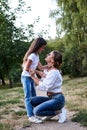 Young blond mother hugging her brunette daughter in the park in summer. Woman and girl, wearing blue jeans and white t-shirts, Royalty Free Stock Photo