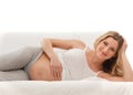 A young blond pregnant Caucasian woman on a sofa