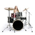 Young blond teenage girl plays the drums in studio against white Royalty Free Stock Photo