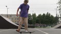 Young blond teenager skater skateboarder man doing 360 kickflip heelflip flip trick jump, ollie, on skateboard in skate