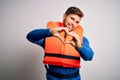 Young blond tourist man with beard and blue eyes wearing lifejacket over white background smiling in love doing heart symbol shape Royalty Free Stock Photo