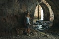 Young blond tourist woman stading in ancient stone shipyard and looking at the sea in the Old city, Alanya, Turkey. Royalty Free Stock Photo