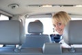 Young blond woman on a backseat of a car