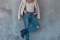 Young blond woman in a beige fashionable leather jacket in a white trendy t-shirt in blue ripped jeans Royalty Free Stock Photo