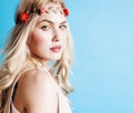 young blond woman dressed like ancient greek godess, beautiful girl hands manicured red nails on blue background