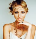 young blond woman dressed like ancient greek godess, gold jewelr