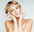 Young blond woman dressed like ancient greek godess, gold jewelry close up isolated