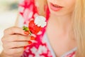 Young blond woman eating strawberries with cream, happy in the garden on a summer sunny day, warm summer tonic image, self-service Royalty Free Stock Photo