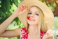 Young blond woman eating strawberries smiling in the garden summer sunny day, warm summer toning image, self care and healthy life Royalty Free Stock Photo