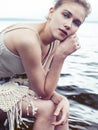 Young blond woman hanging on birch tree at lake shore, summer vacations outdoor lifestyle Royalty Free Stock Photo