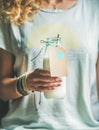 Young blond woman holding bottle of dairy-free almond milk Royalty Free Stock Photo