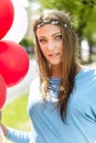 Young blond woman holding colorful balloons in the street. Royalty Free Stock Photo