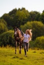 Young blond woman with long hair jockey rider jumping on a bay horse Royalty Free Stock Photo