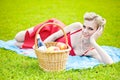 Young blond woman is lying on grass