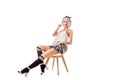 young blond woman in sexy short plaid skirt and knee socks sitting on chair