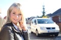 Young blond woman with smartphone and taxicab