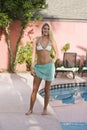 Young blond woman standing by pool Royalty Free Stock Photo