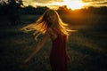 Young blond woman stands on meadow with loose hair lit by sun Royalty Free Stock Photo