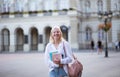 Blond woman on street carrying books